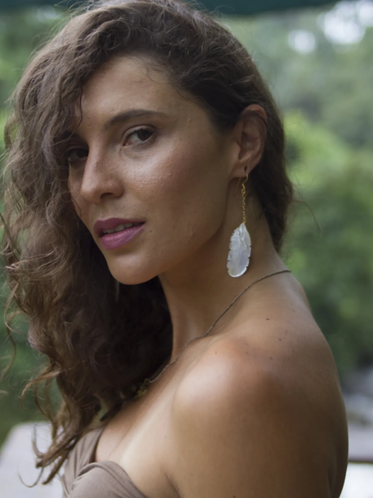 Shell carved earrings of an owl feather